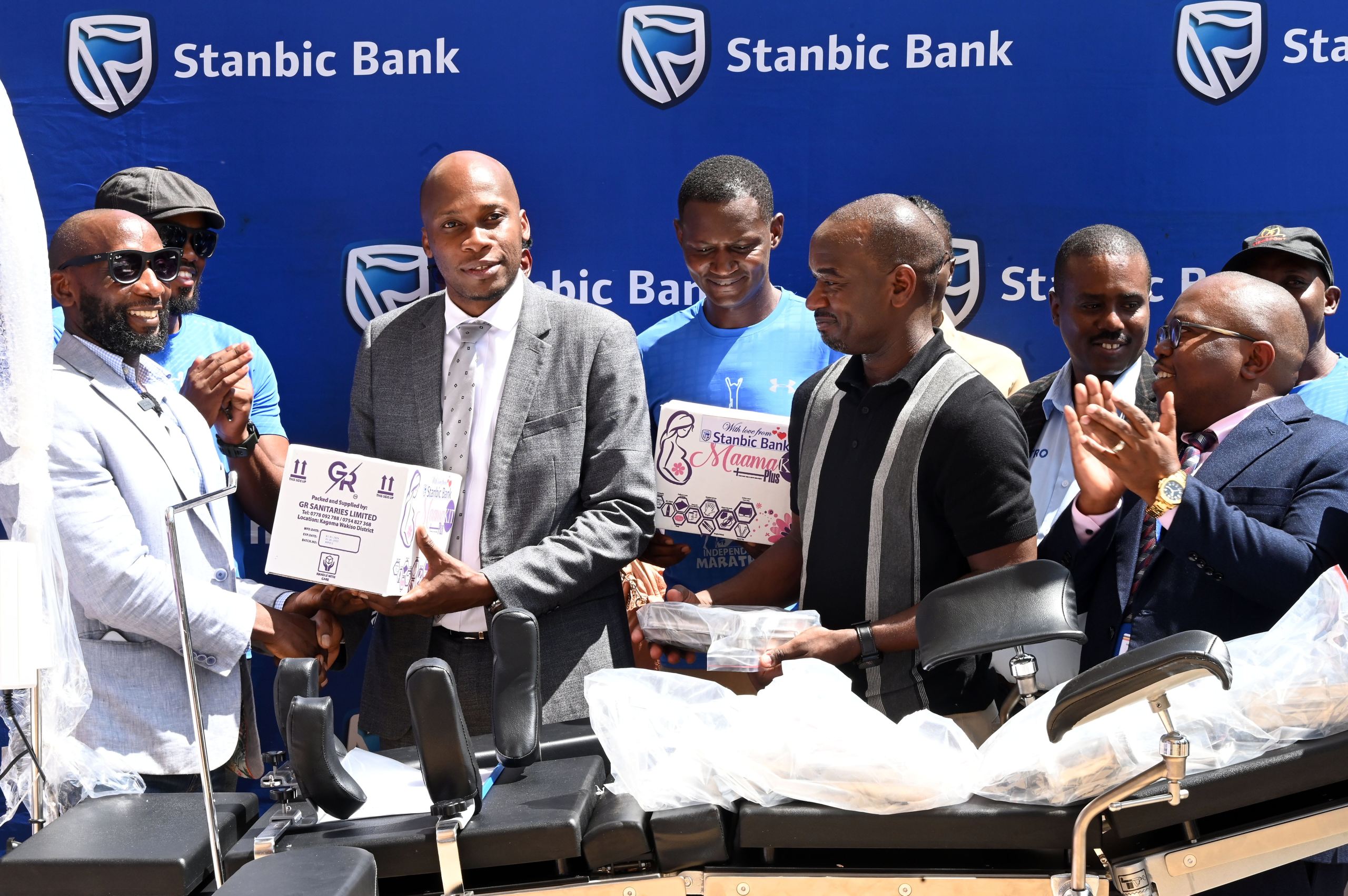 Stanbic Bank's Head of Affluent Banking Arthur Kiwanuka (left), handing over a Mama Kit to the Hospital Director Dr John Bosco Nsubuga as other stakeholders look on.