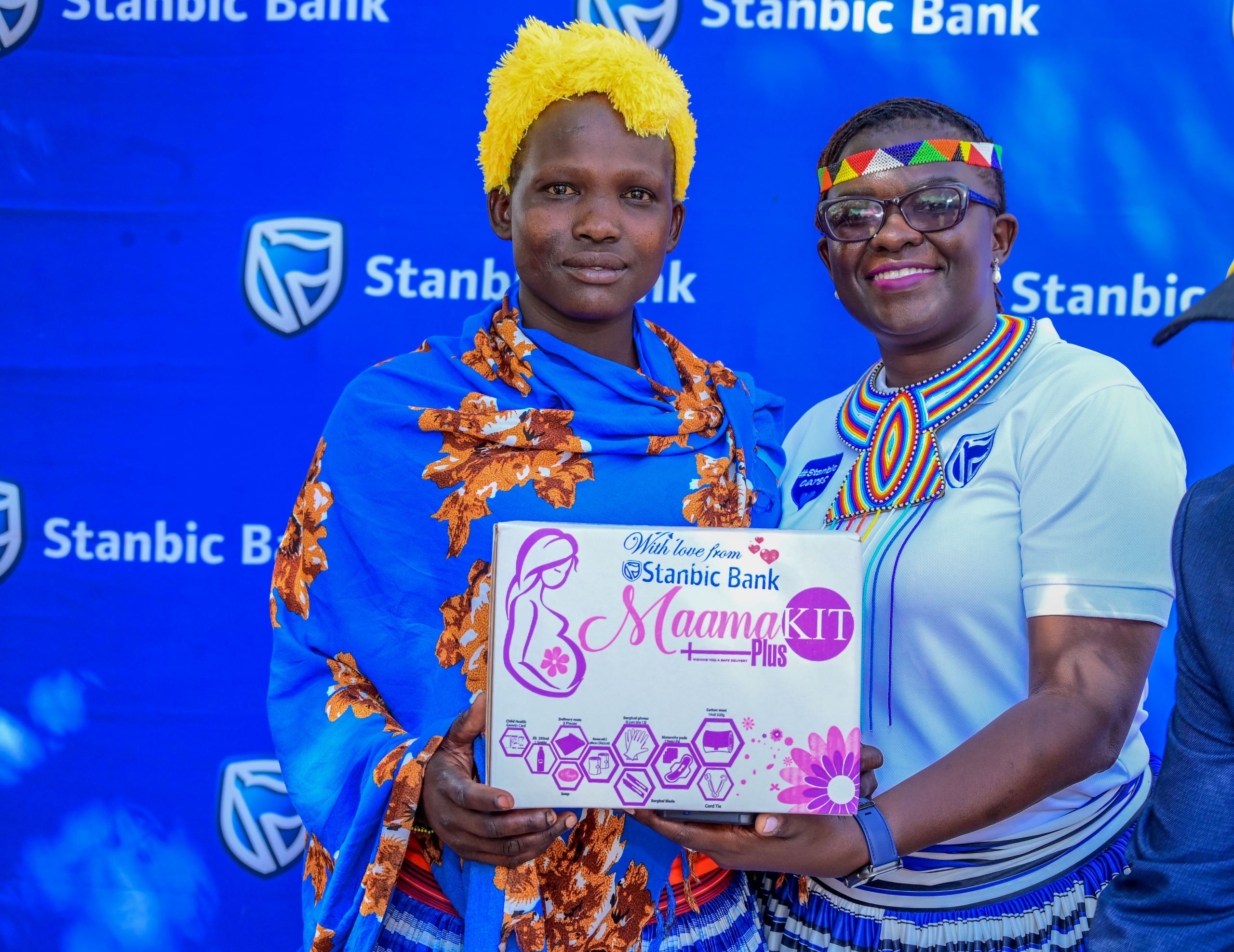 Diana Ondoga, Manager CSI Stanbic Bank hands over a mama kit to an expectant mother