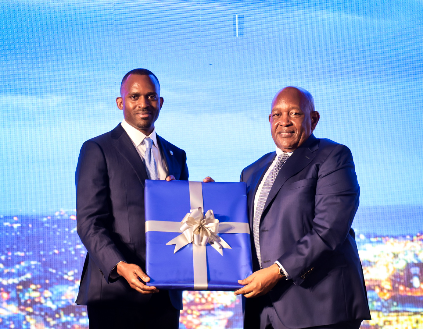 Grace Semakula, Chief Executive Officer of SBG Securities Limited, presents a commemorative gift to businessman Charles Mbire following his keynote address at the inaugural Investor Day Forum in Kampala