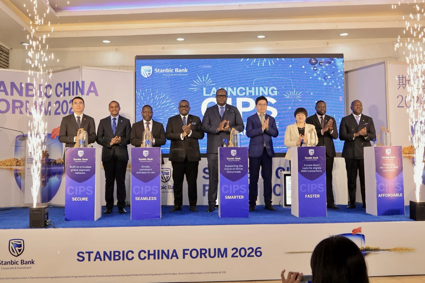 Minister David Bahati (3rd left) posing for a photo with the Stanbic Uganda team led by the Bank's Chief Executive Mumba Kalifungwa(centre) after the launch