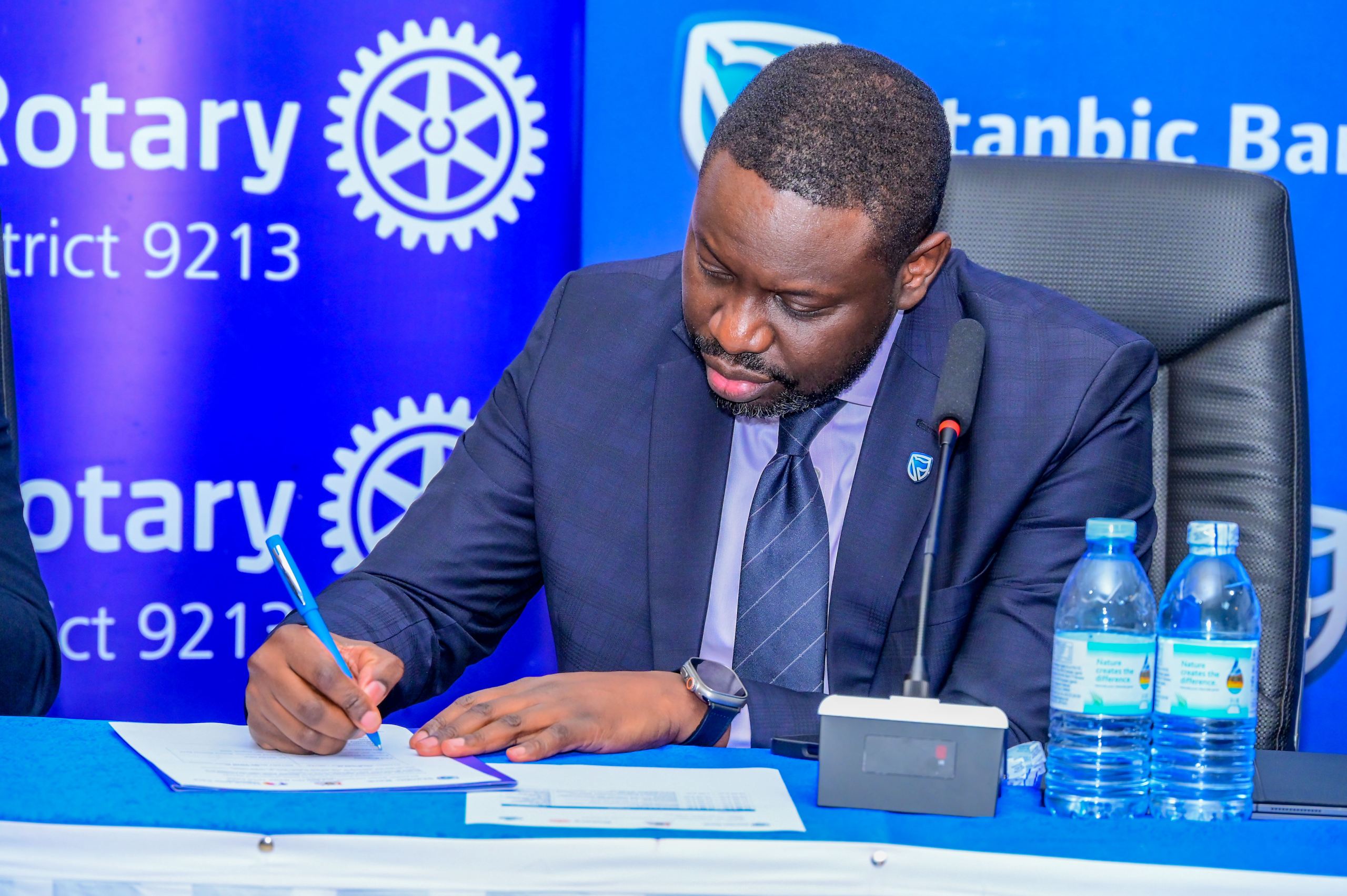 Paul Muganwa Stanbic Bank Executive Director signing the partnership agreement