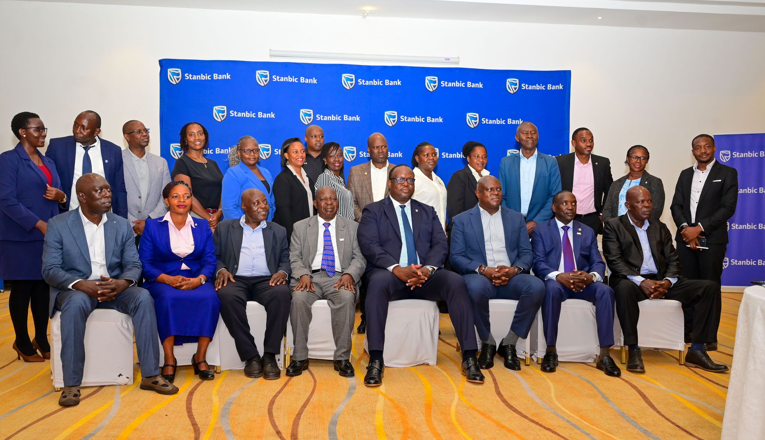 Stanbic Uganda Holdings leaders, led by Mark Ocitti Ongom and Mumba Kalifungwa, pose for a group photo with stakeholders during a customer engagement session at Brovad Sands Hotel in Kalangala District.