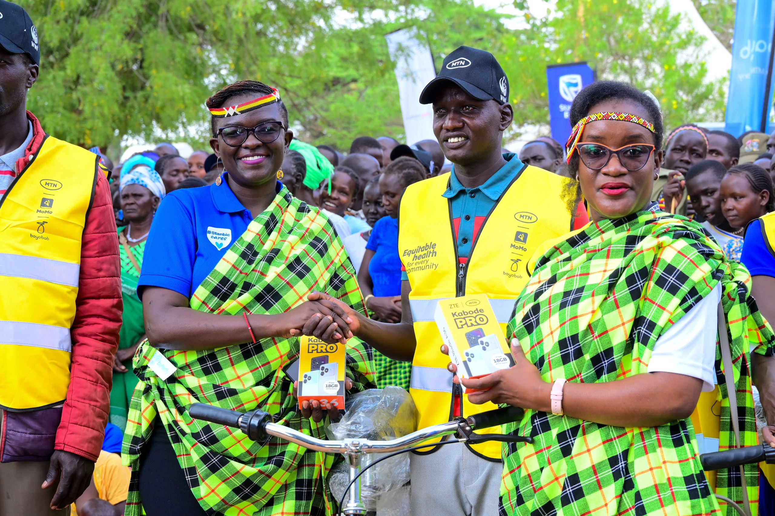 Stanbic’s CSI Manager,Diana Ondoga (L) handsover a phone donated by MTN to one of the VHT’s alongside Dr Ruth Grace Kakoba, MoH’s Technical Advisor for Maternal and Newborn Health.JPG Stanbic's CSI Manager,Diana Ondoga (L) handsover a phone donated by MTN to one of the VHT's alongside Dr Ruth Grace Kakoba, MoH's Technical Advisor for Maternal and Newborn Health