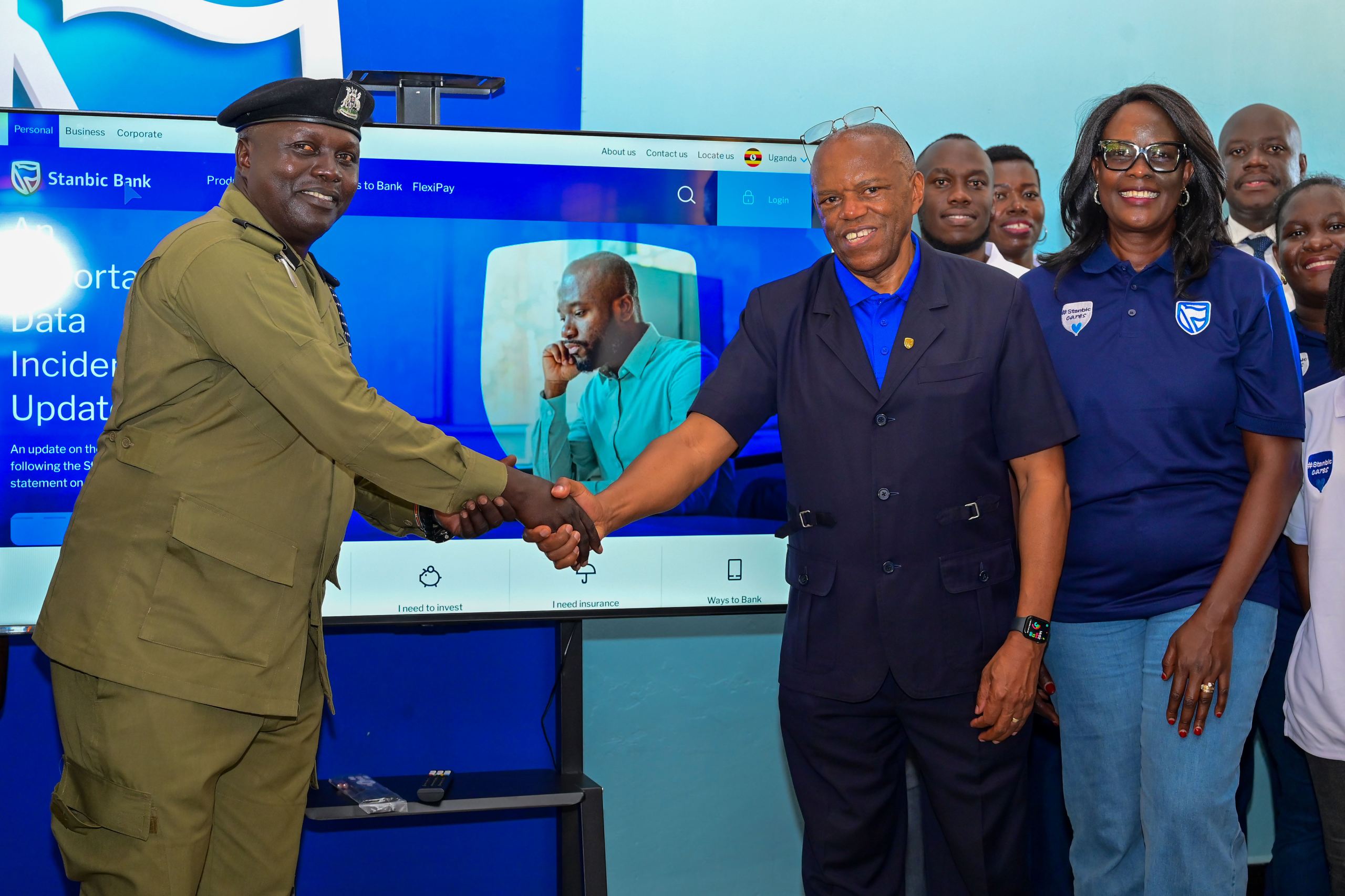 Damoni Kitabire, Chairperson of the Board of Directors at Stanbic Bank Uganda handing over a 5 inch television to Senior Superintendent of Police (SSP) James Okabo Okello Damoni Kitabire, Chairperson of the Board of Directors at Stanbic Bank Uganda handing over a 5 inch television to Senior Superintendent of Police (SSP) James Okabo Okello