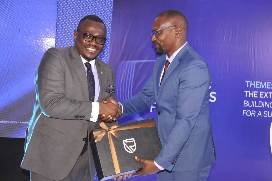 Tunde Thorpe (left), the Executive Head of Business and Commercial Banking at Stanbic Bank handing over a gift to Hassan Nkuutu Tunde Thorpe (left), the Executive Head of Business and Commercial Banking at Stanbic Bank handing over a gift to Hassan Nkuutu